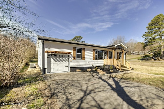 single story home with central air condition unit, a garage, and driveway