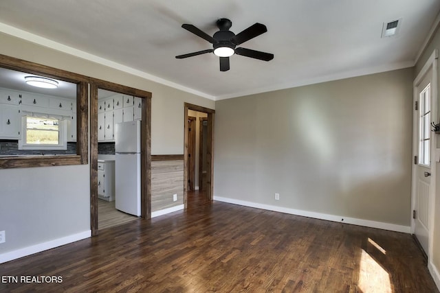 unfurnished room featuring visible vents, baseboards, dark wood-type flooring, and a ceiling fan