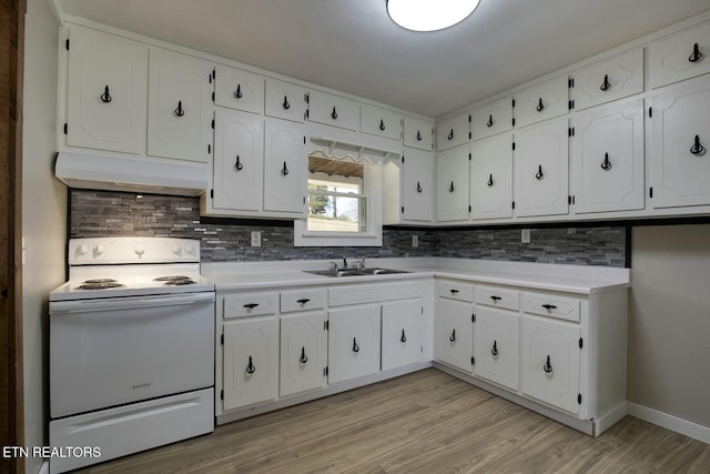 kitchen with under cabinet range hood, decorative backsplash, white cabinets, white electric range, and a sink