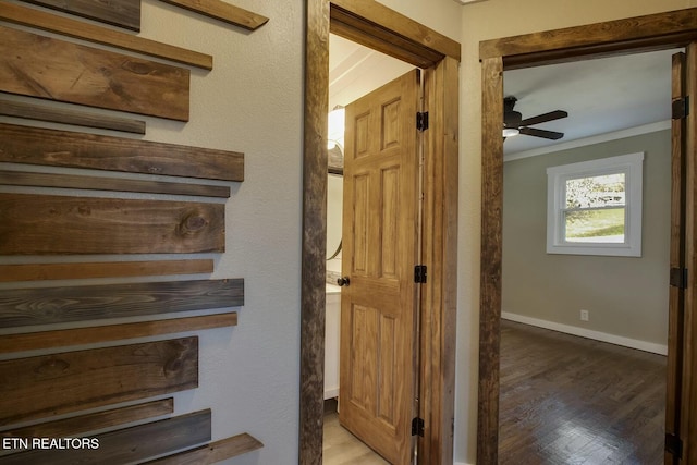 stairs with crown molding, wood finished floors, baseboards, and ceiling fan