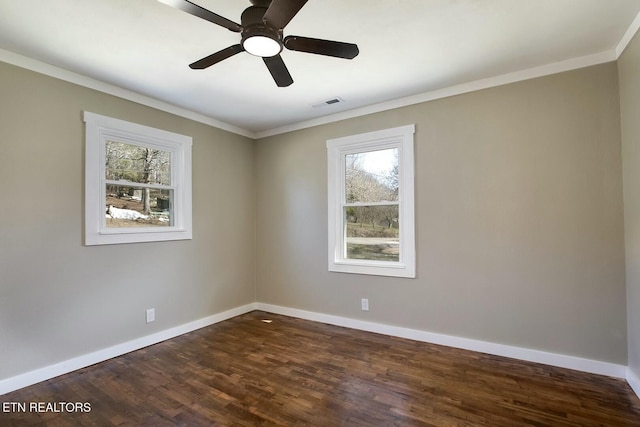 unfurnished room with dark wood-style floors, baseboards, visible vents, and ornamental molding