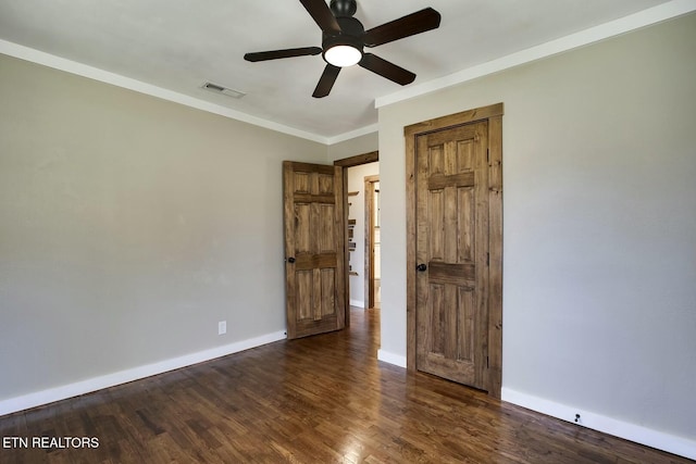 unfurnished bedroom featuring visible vents, crown molding, baseboards, ceiling fan, and dark wood-style flooring