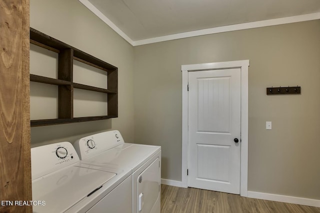 clothes washing area with light wood-style floors, baseboards, separate washer and dryer, and laundry area