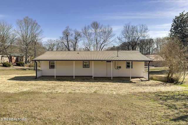 back of property with a lawn and metal roof