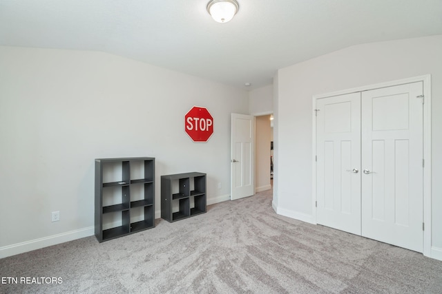 unfurnished bedroom with carpet floors, baseboards, and vaulted ceiling