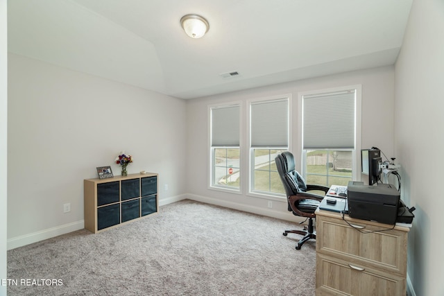 carpeted home office featuring vaulted ceiling, visible vents, and baseboards