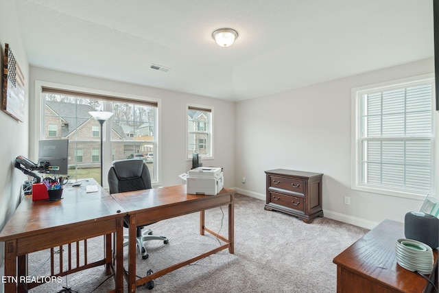 home office with baseboards, visible vents, and light colored carpet