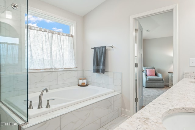 bathroom featuring double vanity, lofted ceiling, a garden tub, walk in shower, and a sink