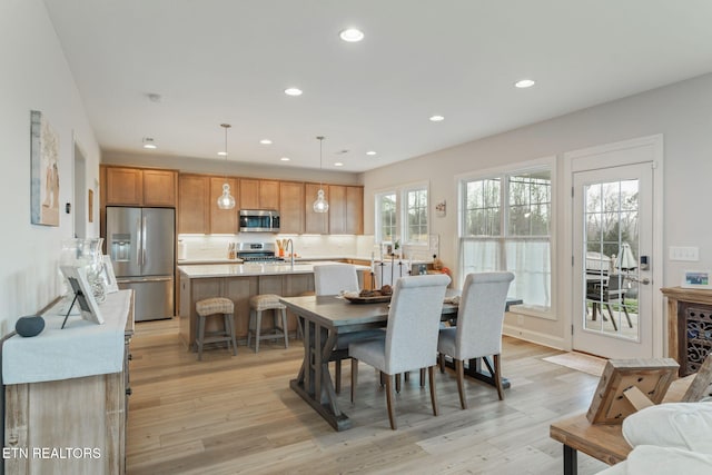 dining area with recessed lighting and light wood-style flooring