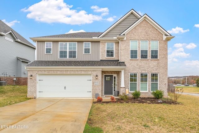 craftsman inspired home with a garage, concrete driveway, a front lawn, and brick siding