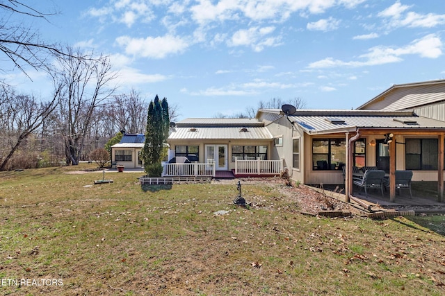 back of house featuring metal roof, a patio, and a yard