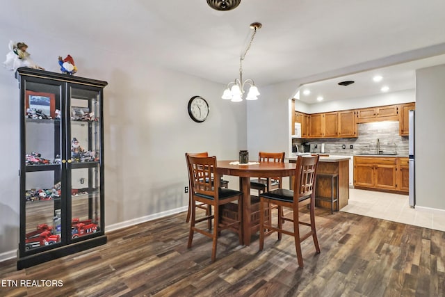 dining space with recessed lighting, wood finished floors, baseboards, and a chandelier