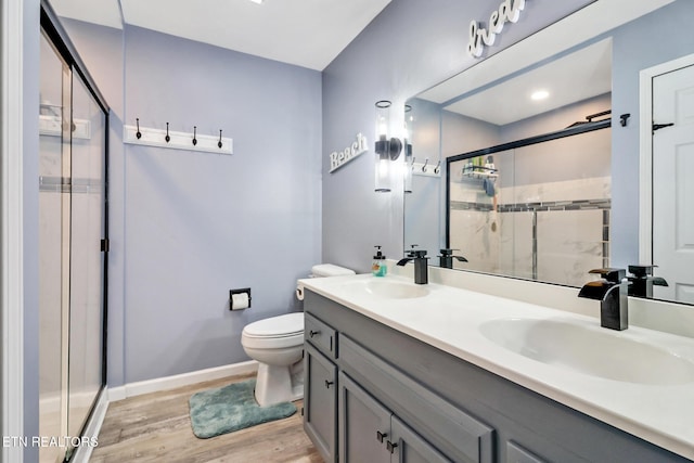 full bathroom featuring a sink, toilet, wood finished floors, and a shower stall