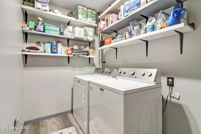 laundry room with laundry area, baseboards, light wood finished floors, and washer and clothes dryer