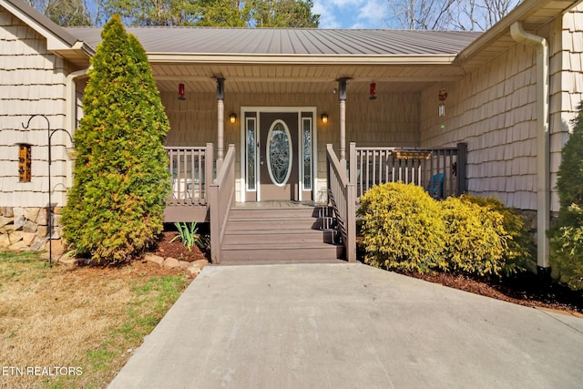 view of exterior entry featuring covered porch