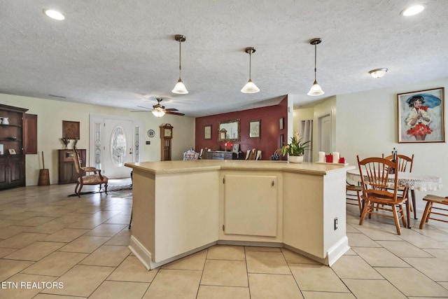 kitchen with light tile patterned floors, light countertops, ceiling fan, and pendant lighting