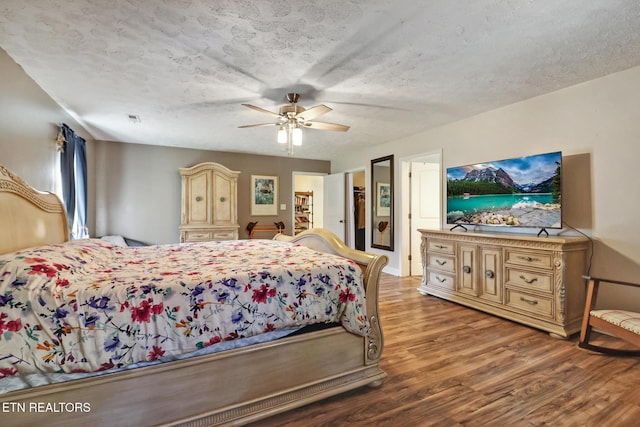 bedroom featuring ceiling fan, a textured ceiling, and wood finished floors