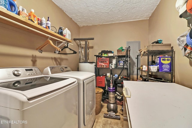 laundry area featuring laundry area, wood finished floors, a textured ceiling, washing machine and dryer, and water heater