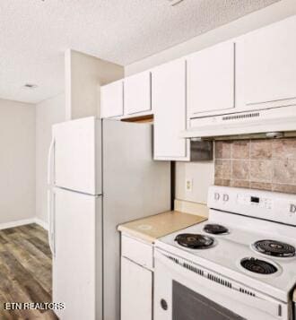 kitchen featuring under cabinet range hood, light countertops, white cabinets, white appliances, and a textured ceiling