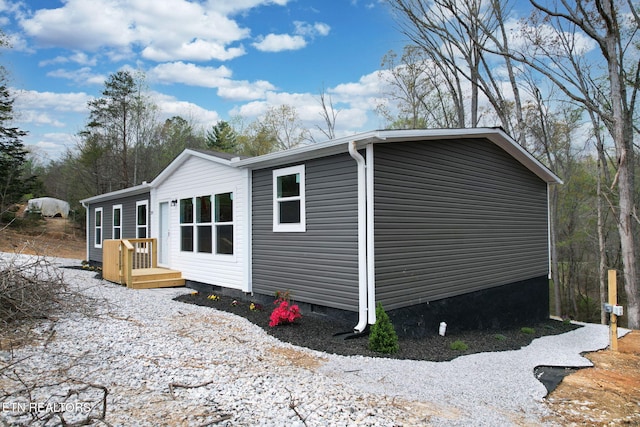 view of home's exterior with a wooden deck and crawl space