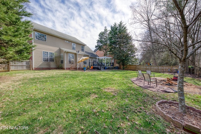 view of yard featuring a fenced backyard, a fire pit, and a patio