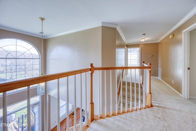 hallway with carpet, baseboards, crown molding, and an upstairs landing