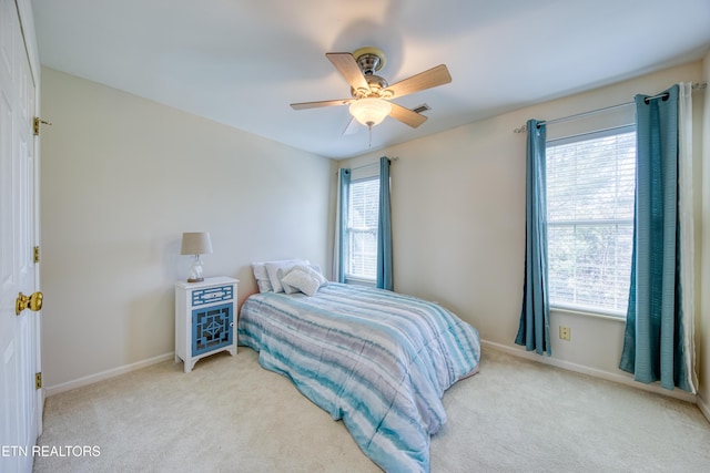 carpeted bedroom with a ceiling fan, visible vents, and baseboards