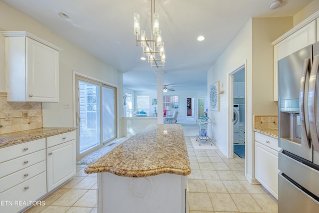 kitchen with light tile patterned floors, backsplash, open floor plan, white cabinets, and stainless steel fridge with ice dispenser