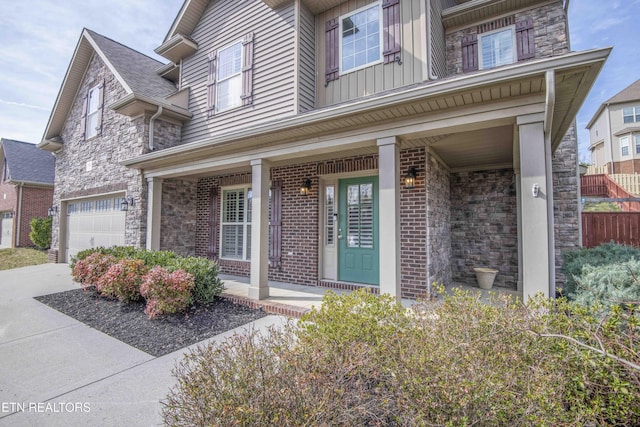 property entrance with brick siding, a porch, board and batten siding, a garage, and stone siding