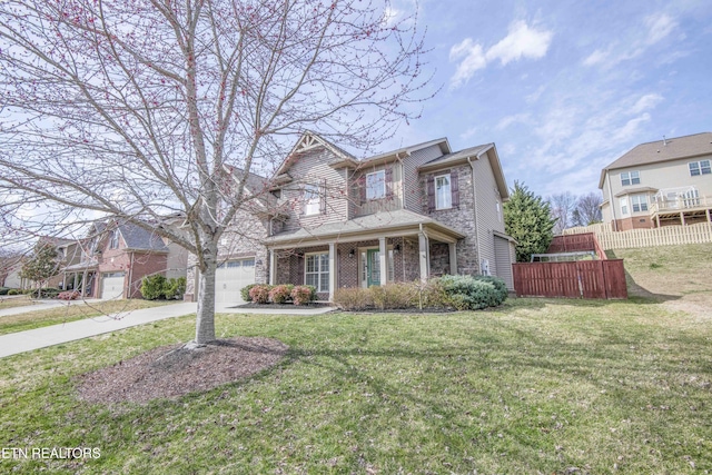 traditional-style home with driveway, fence, a front lawn, and brick siding