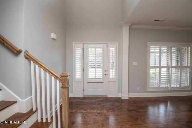 entrance foyer with stairs, ornamental molding, wood finished floors, and a wealth of natural light