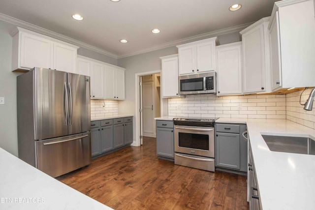 kitchen with stainless steel appliances, gray cabinets, light countertops, and a sink