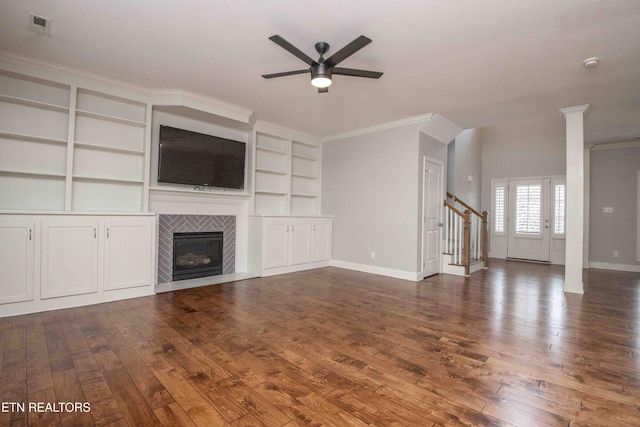 unfurnished living room featuring a fireplace, stairway, ornamental molding, baseboards, and hardwood / wood-style flooring