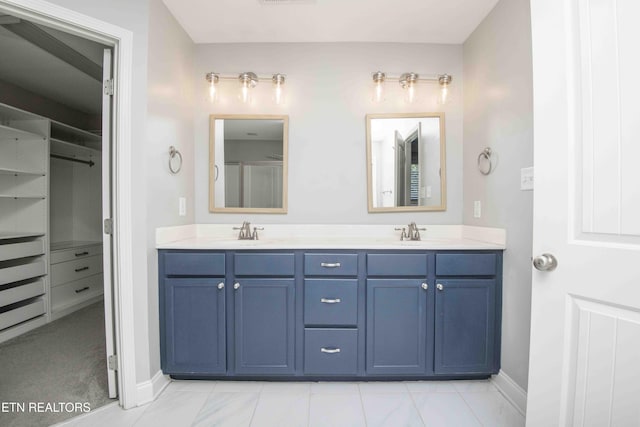 bathroom with a sink, baseboards, and double vanity