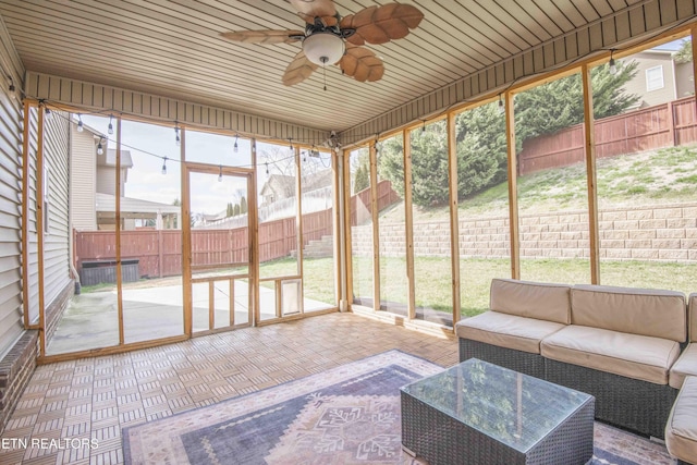 unfurnished sunroom with a ceiling fan