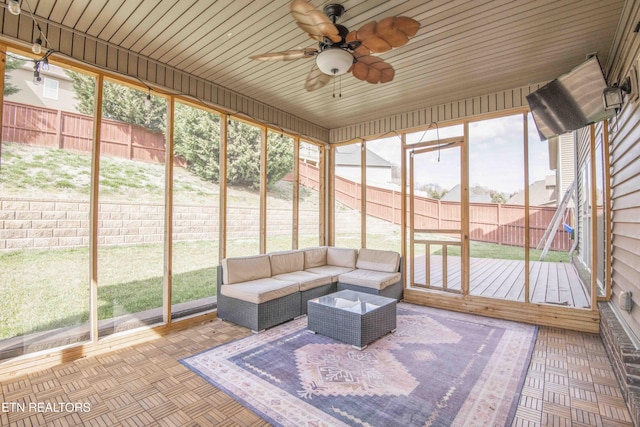 unfurnished sunroom with ceiling fan