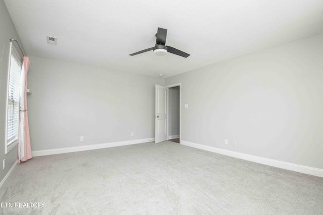 unfurnished room with carpet flooring, ceiling fan, visible vents, and baseboards