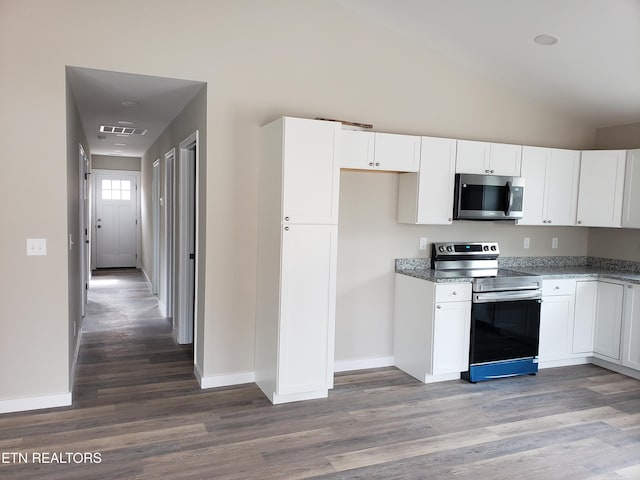 kitchen featuring stainless steel appliances, visible vents, white cabinetry, vaulted ceiling, and wood finished floors