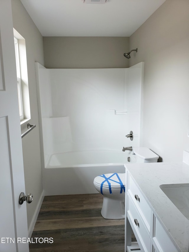 bathroom with bathtub / shower combination, visible vents, toilet, vanity, and wood finished floors