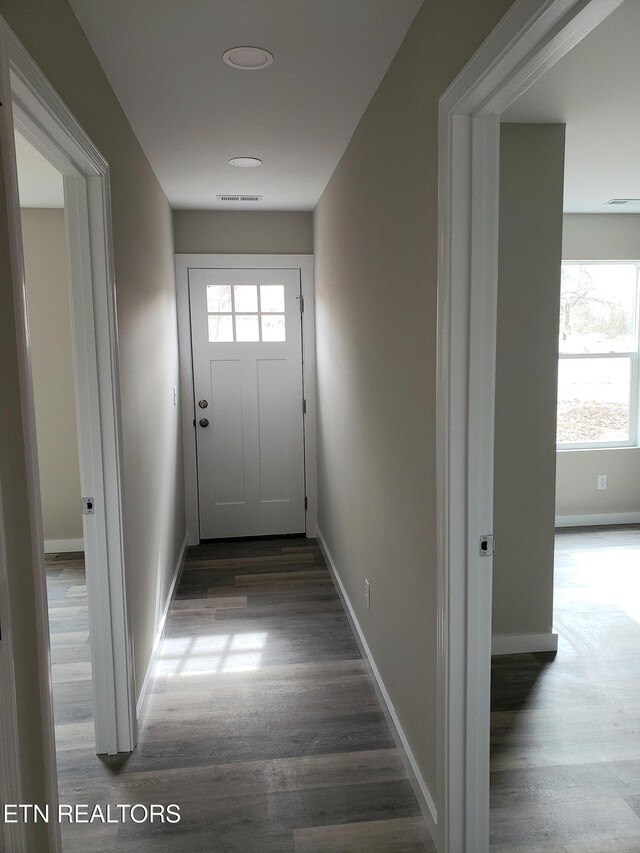 interior space with wood finished floors, visible vents, and baseboards