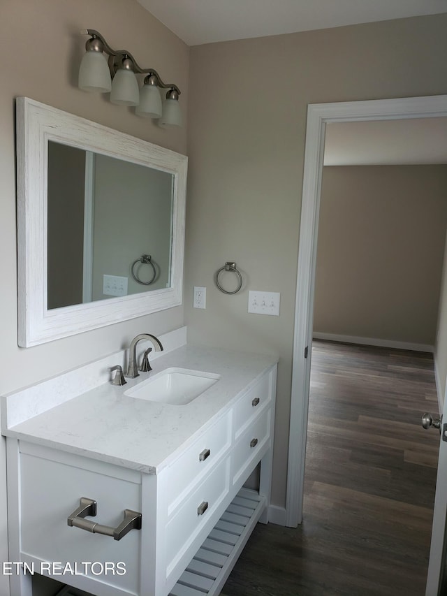 bathroom with vanity, baseboards, and wood finished floors