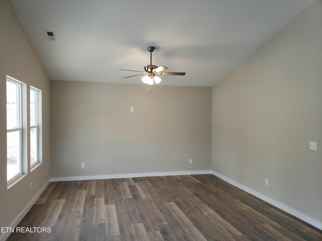 spare room with dark wood finished floors, lofted ceiling, visible vents, ceiling fan, and baseboards