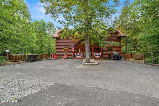 view of front of house featuring crawl space, faux log siding, and metal roof