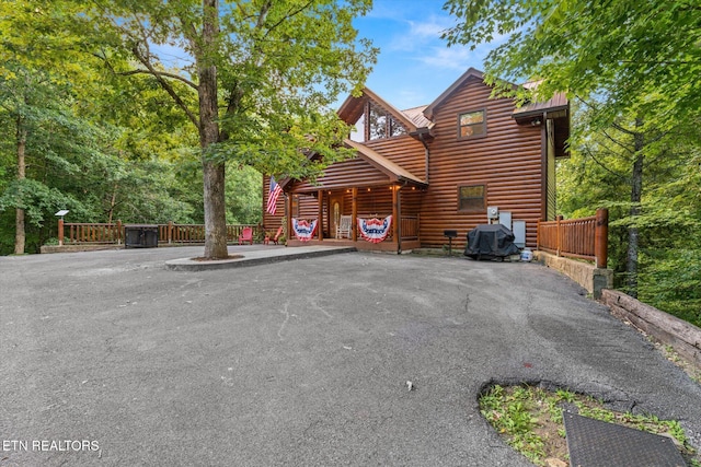 view of front facade with faux log siding and fence