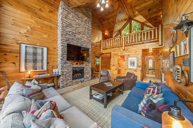 living area with a stone fireplace, wood finished floors, wood ceiling, and wooden walls