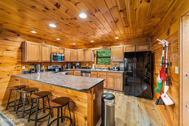 kitchen featuring wooden ceiling, a peninsula, stainless steel appliances, wood walls, and light wood-style floors