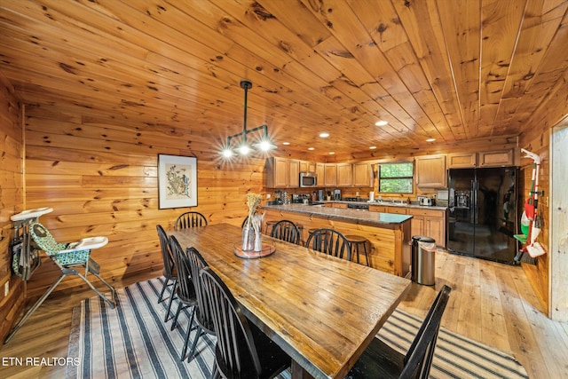 dining area featuring wood ceiling, wood walls, and light wood-style flooring