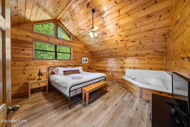 bedroom with light wood-style floors, wood ceiling, vaulted ceiling, and wooden walls