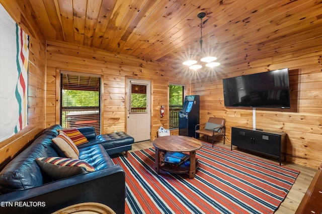 living room featuring wood walls, wooden ceiling, wood finished floors, and an inviting chandelier