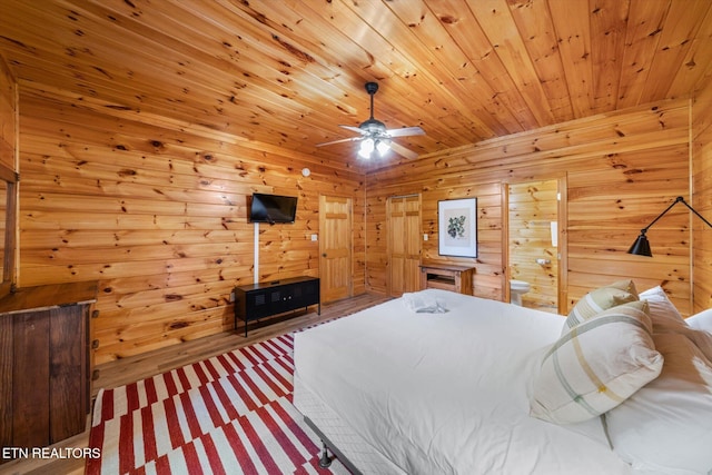 bedroom featuring ensuite bath, wood ceiling, and wooden walls